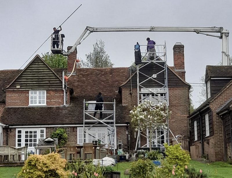 The Moss Cleaners using cherry picker and scaffolding to clean roof safely and professionally in Addlestone, Surrey